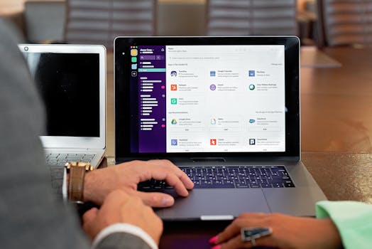 Two professionals collaborating using laptops and communication software in a business setting.
